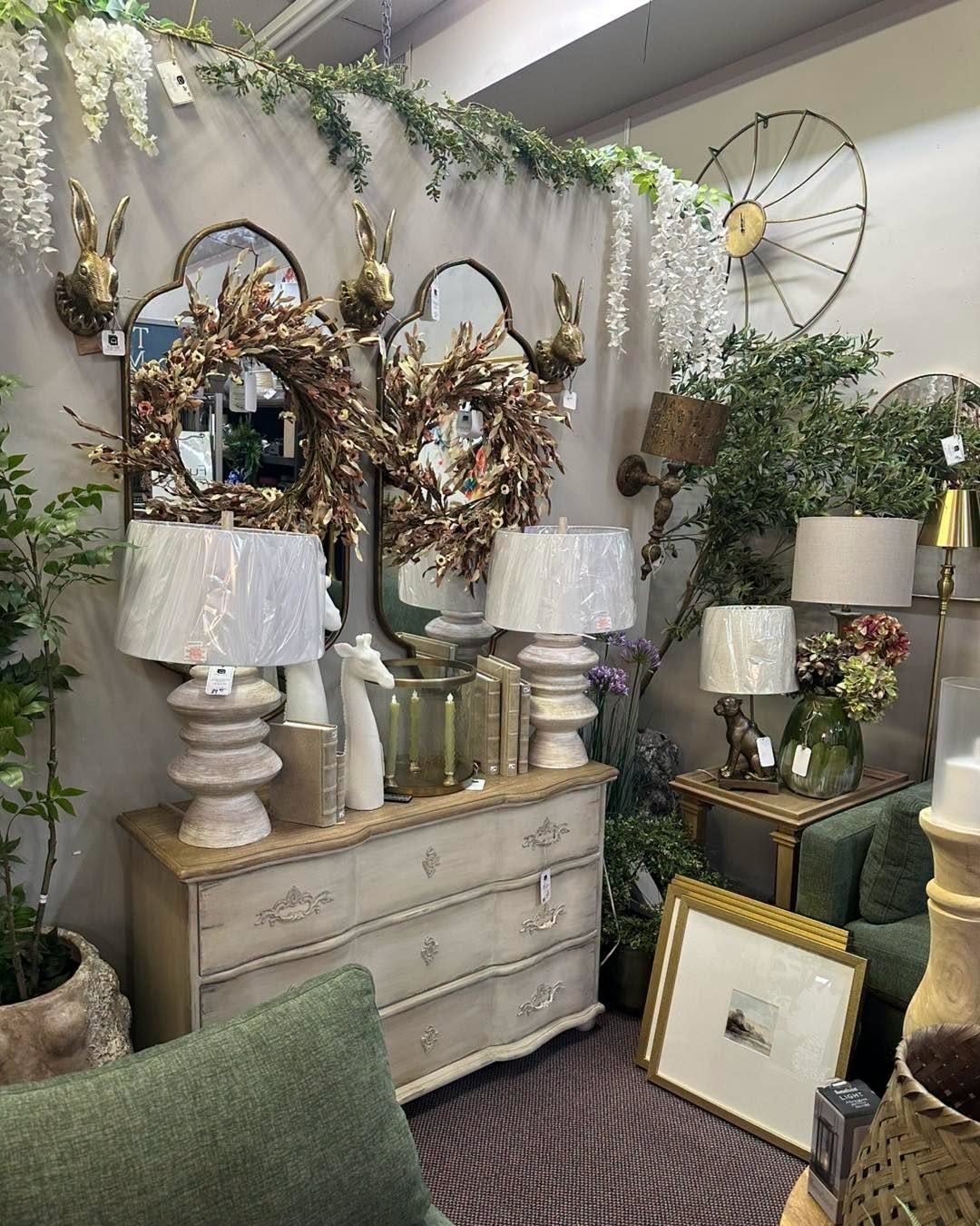 A cream dresser styled with lamps, wreaths and mirrors in our showroom