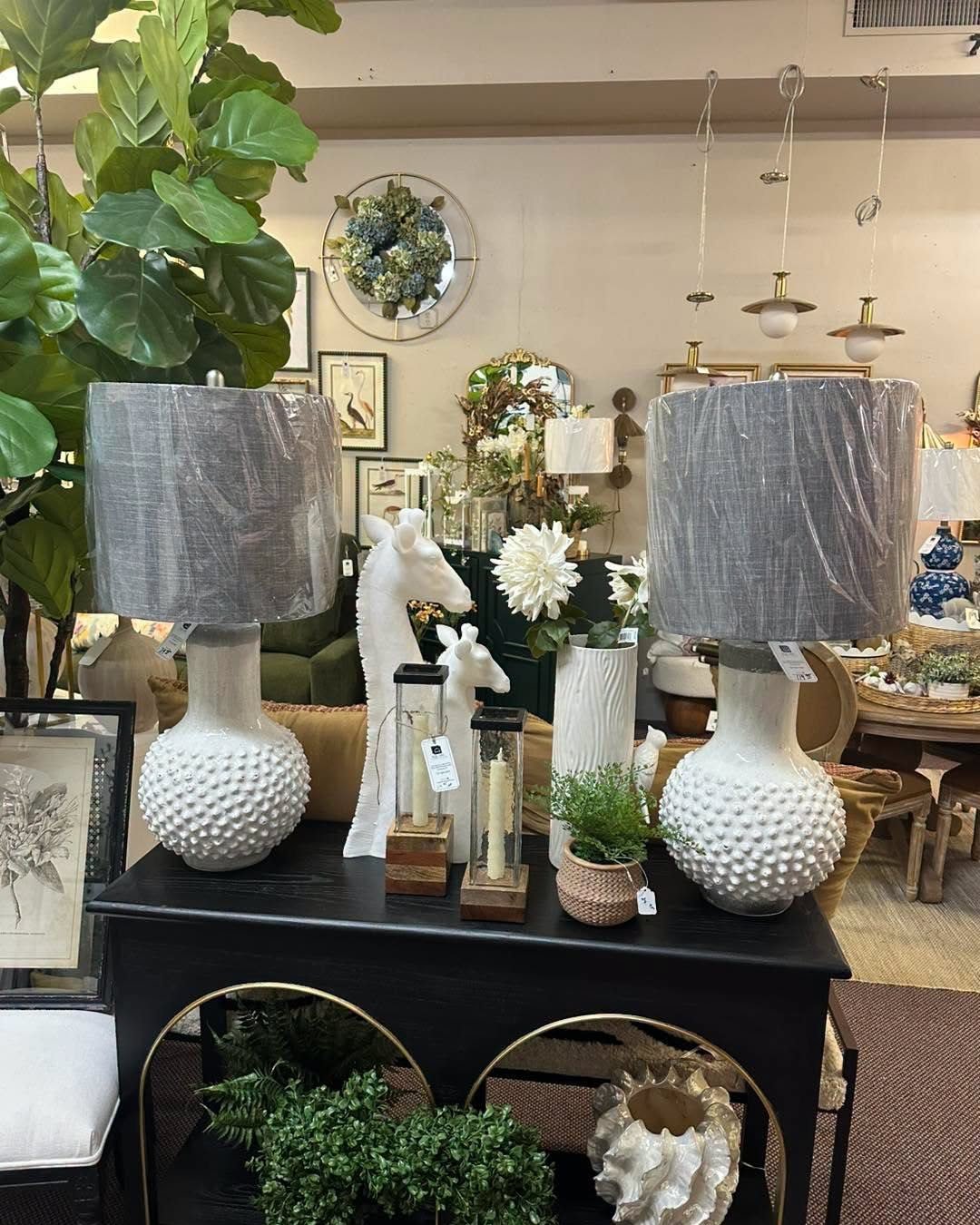 White table lamps with gray shades on a black console in our showroom